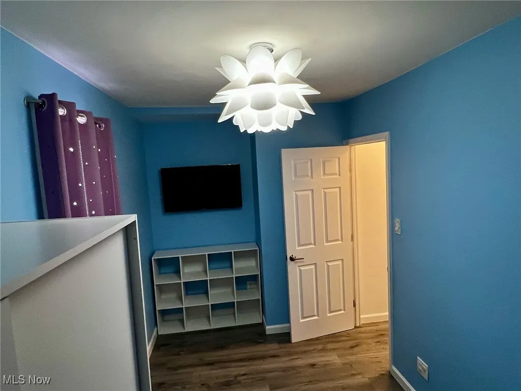 Unfurnished bedroom with dark hardwood / wood-style flooring