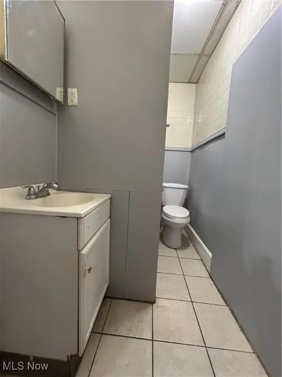 Bathroom featuring tile patterned floors, vanity, and toilet
