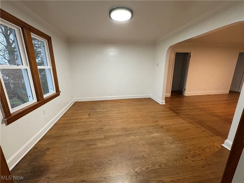 Room with a healthy amount of sunlight and dark hardwood flooring