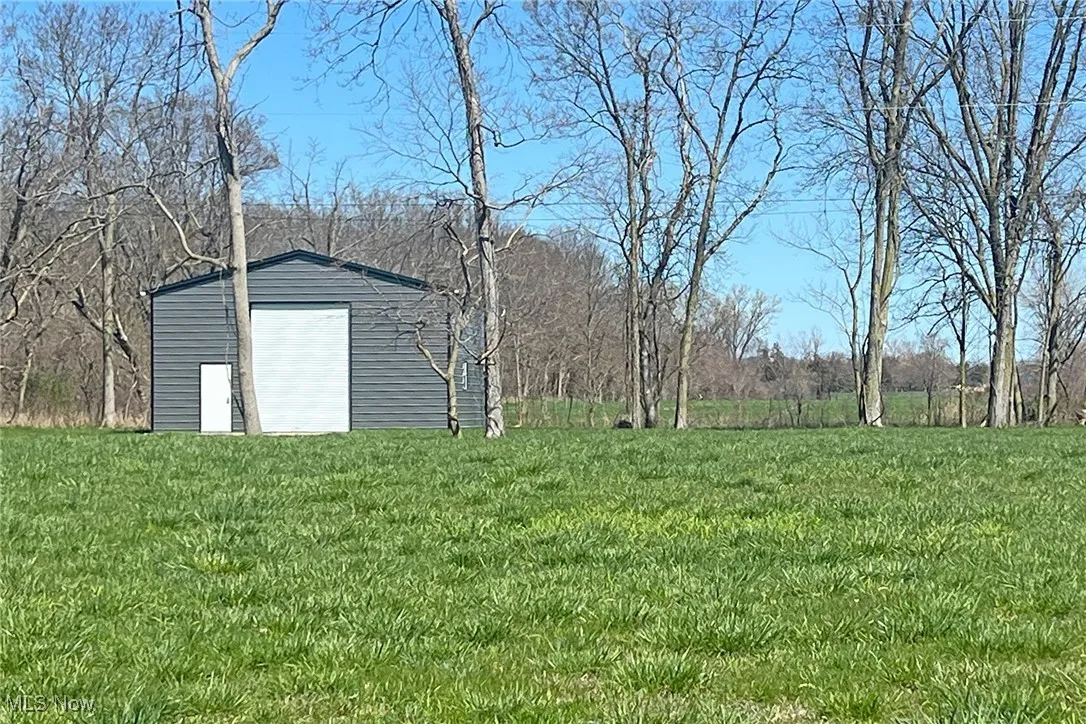 View of yard featuring an outdoor structure and a garage