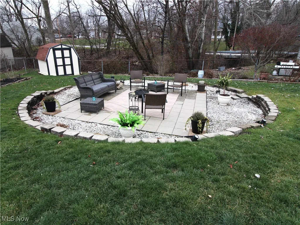 Rear view of the circle patio with a fire pit and the storage shed