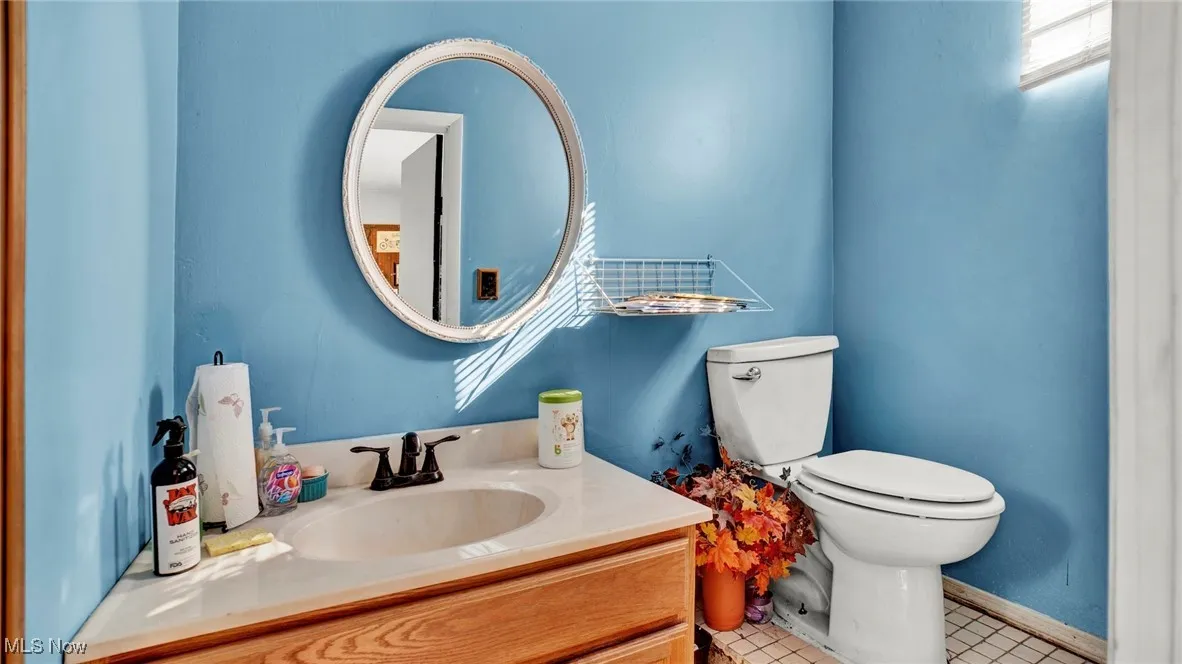Bathroom featuring tile patterned flooring, vanity, and toilet