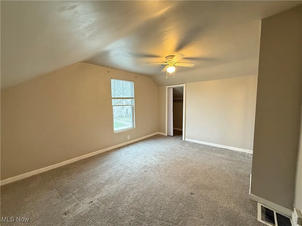 Additional living space featuring baseboards, carpet flooring, visible vents, and vaulted ceiling