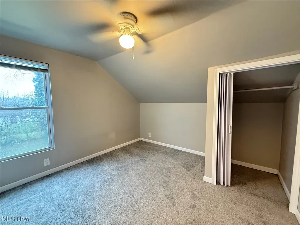 Bonus room featuring a ceiling fan, carpet, baseboards, and vaulted ceiling