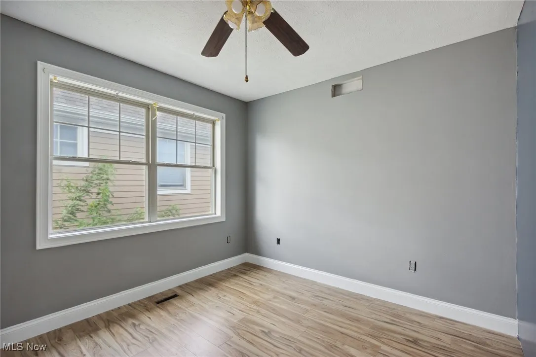 Spare room featuring ceiling fan and light hardwood / wood-style floors