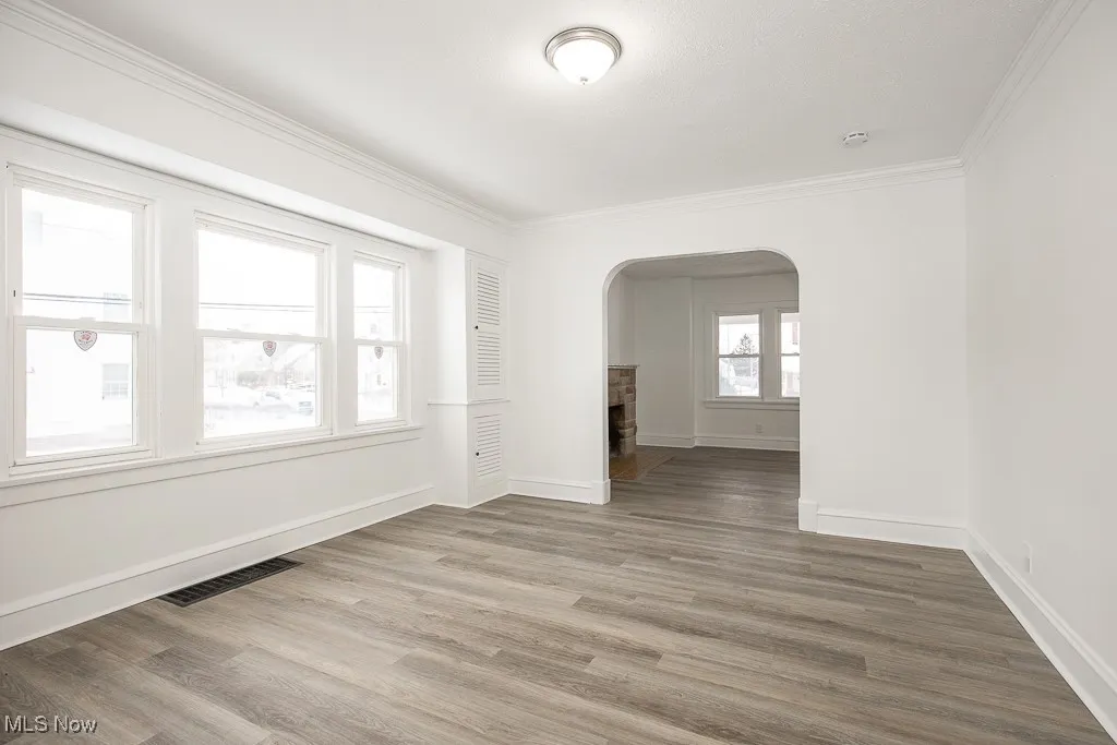Empty room featuring crown molding and wood-type flooring