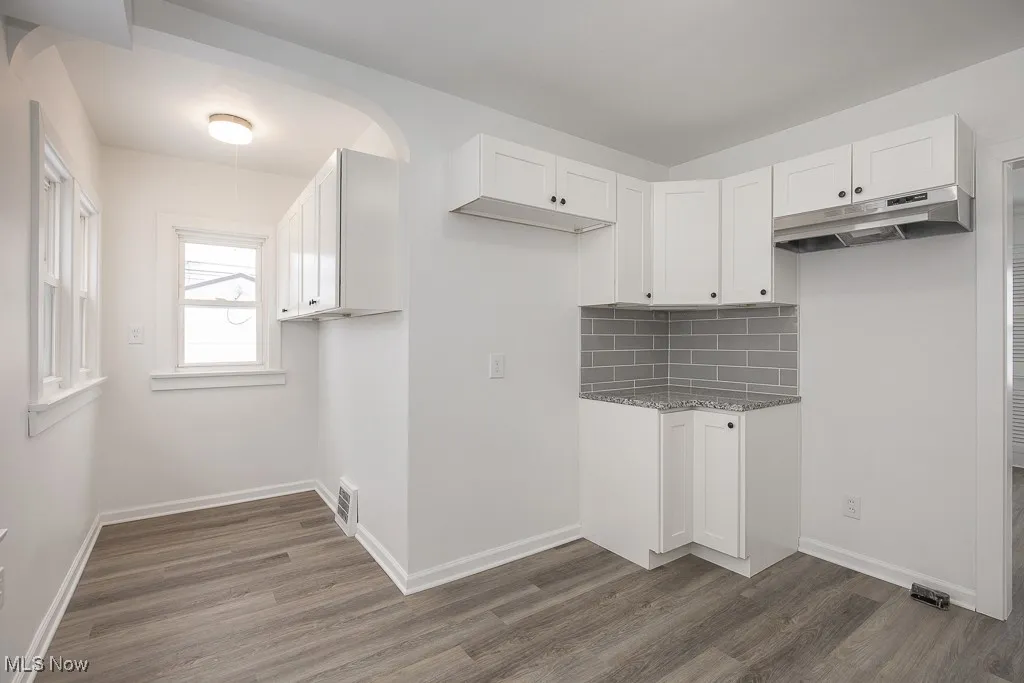 Laundry area with dark hardwood / wood-style flooring