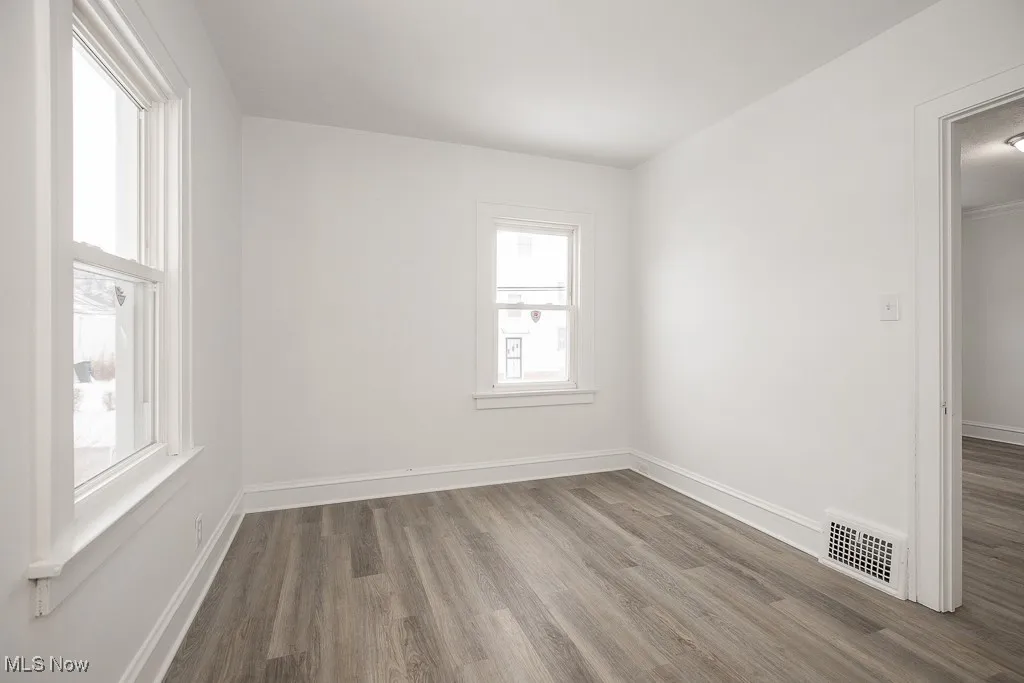 Unfurnished room featuring hardwood / wood-style flooring and a wealth of natural light