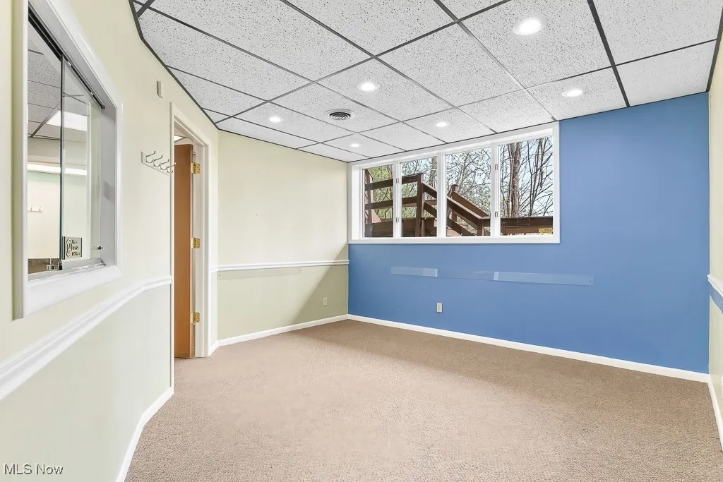 Carpeted empty room with baseboards, a paneled ceiling, recessed lighting, and visible vents
