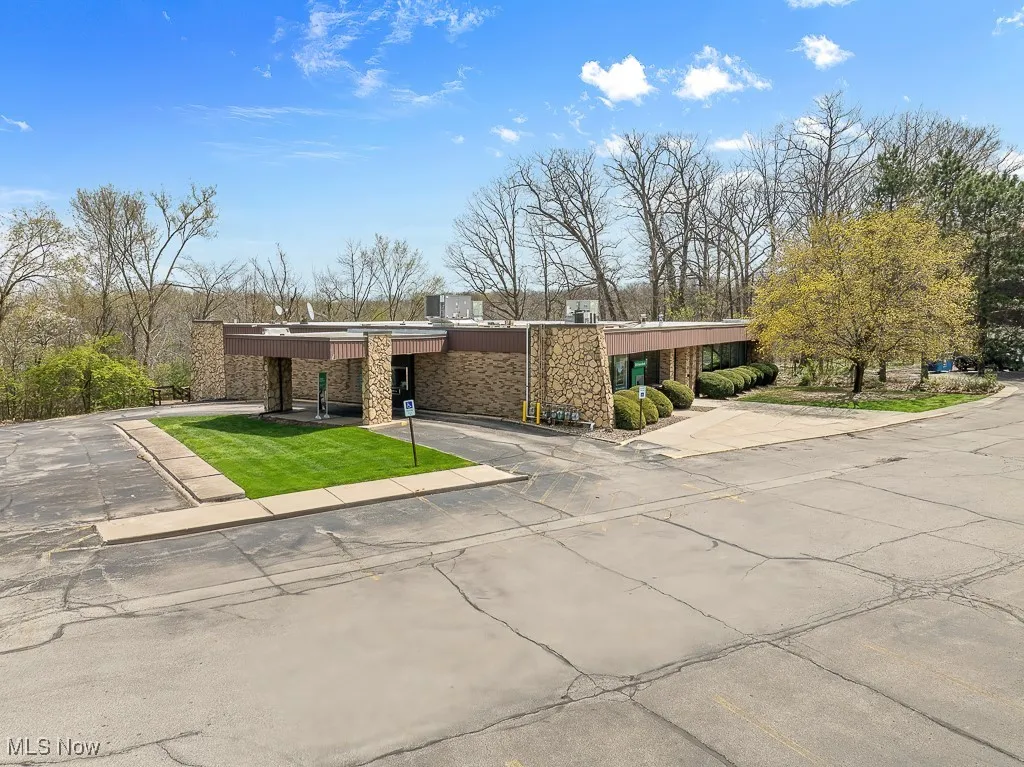 View of front of property with stone siding and uncovered parking