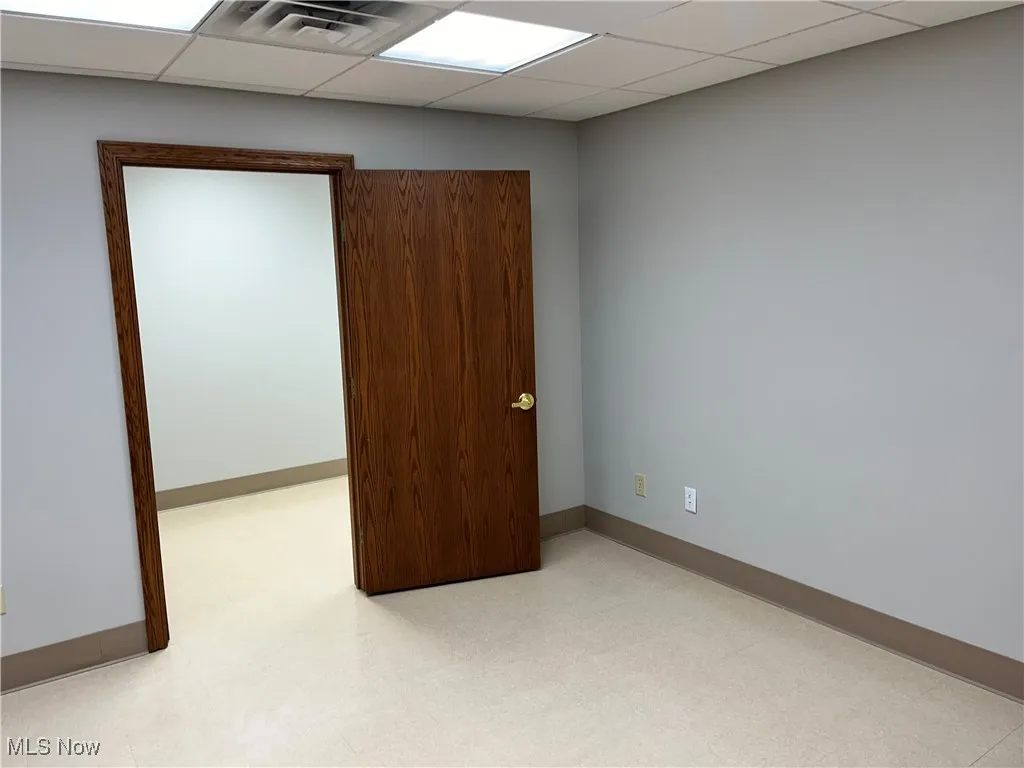 Spare room with baseboards and a paneled ceiling
