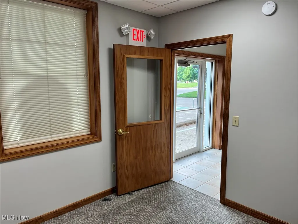 Entryway featuring a drop ceiling and carpet flooring
