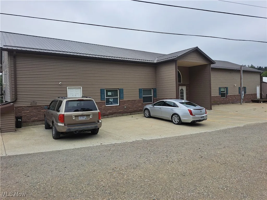 View of front of property with a metal roof and brick siding