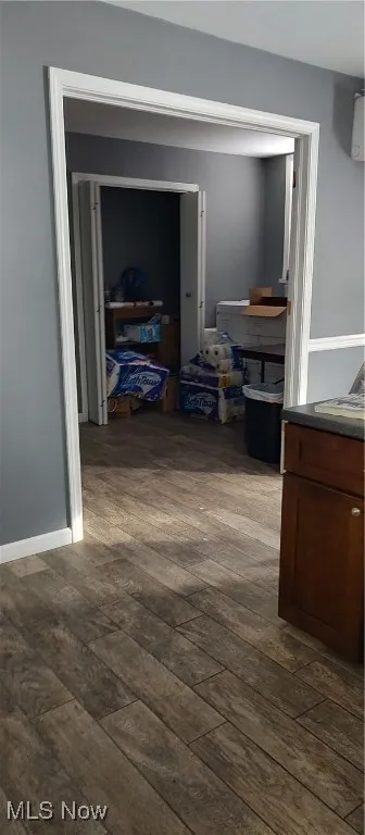 Hall with dark hardwood / wood-style flooring