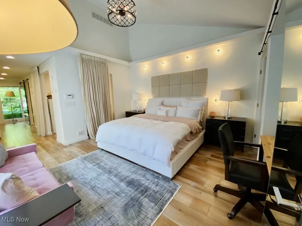 Bedroom featuring high vaulted ceiling and light hardwood / wood-style floors
