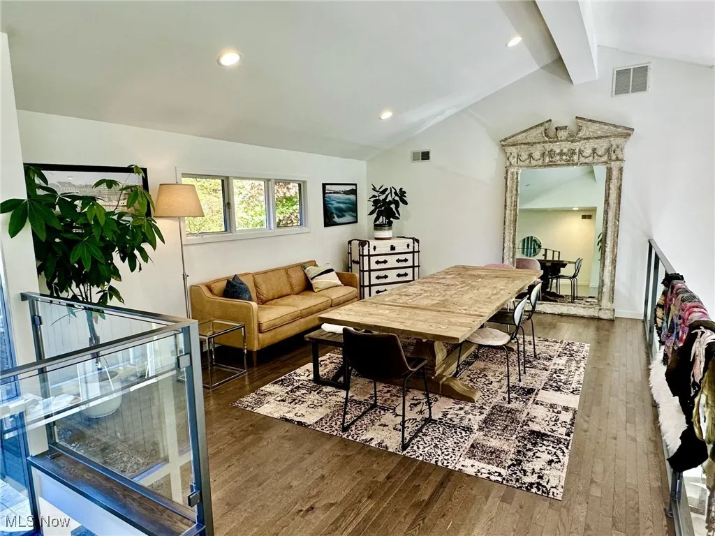 Living room featuring vaulted ceiling with beams and dark wood-type flooring