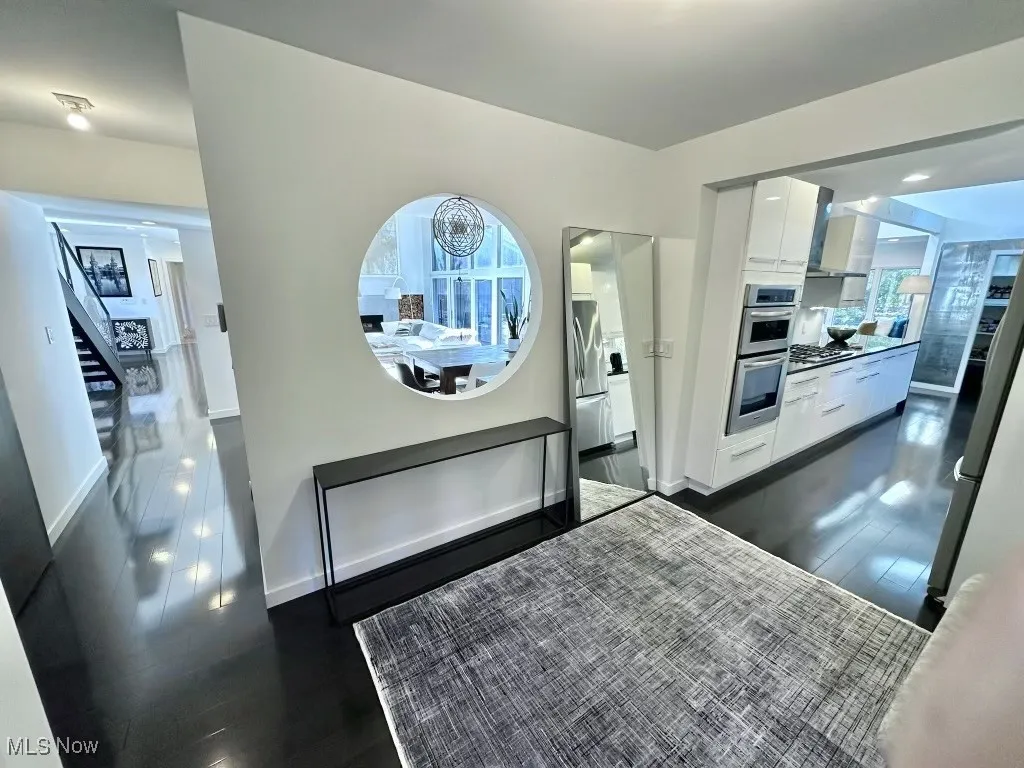 Kitchen with white cabinets, dark hardwood / wood-style flooring, and stainless steel appliances