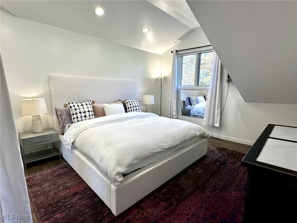 Bedroom featuring vaulted ceiling and dark hardwood / wood-style floors