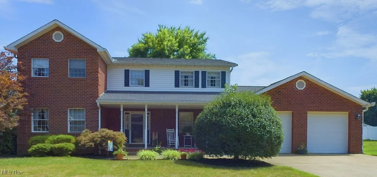 Front facade with a front lawn, a garage, and a porch