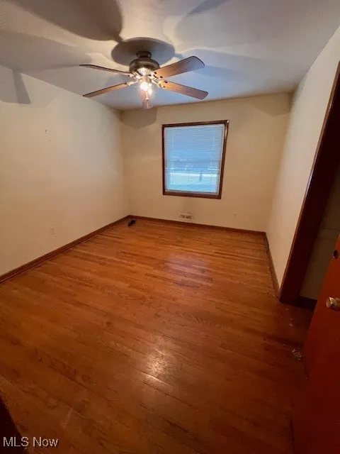 Unfurnished room with wood-type flooring and ceiling fan