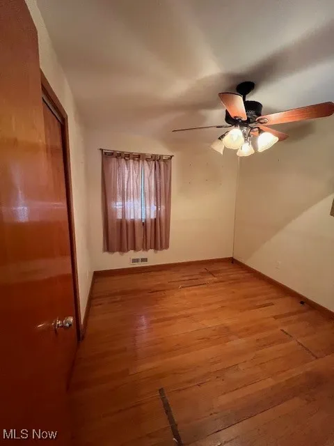 Empty room with light wood-type flooring and ceiling fan