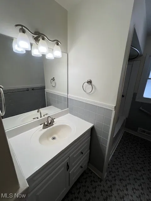 Bathroom with tile walls and vanity