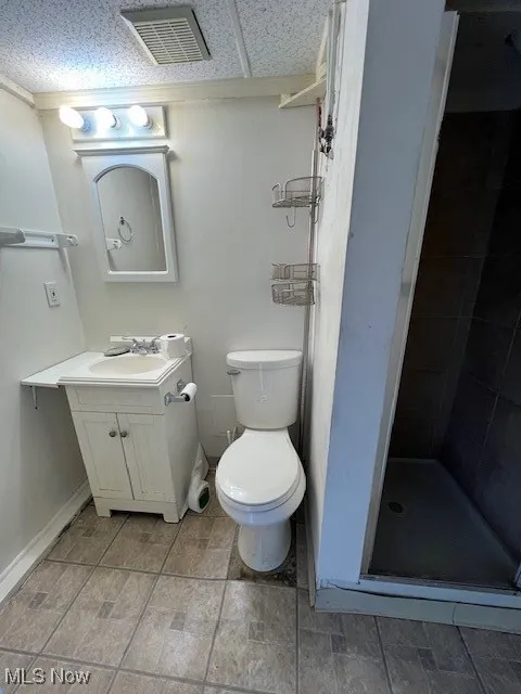 Bathroom featuring vanity, toilet, and a shower with shower door