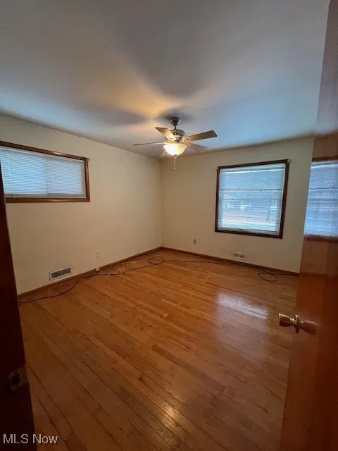Unfurnished room with ceiling fan and light hardwood / wood-style flooring
