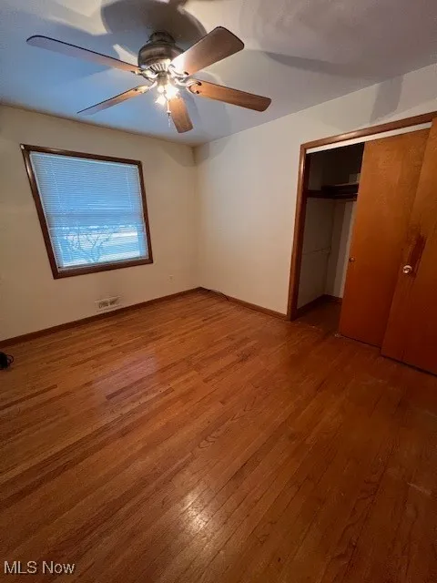 Unfurnished bedroom with ceiling fan, a closet, and hardwood / wood-style floors