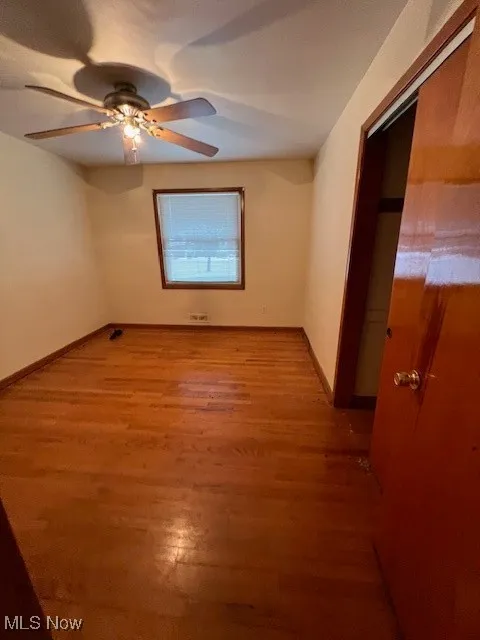 Empty room with ceiling fan and hardwood / wood-style floors