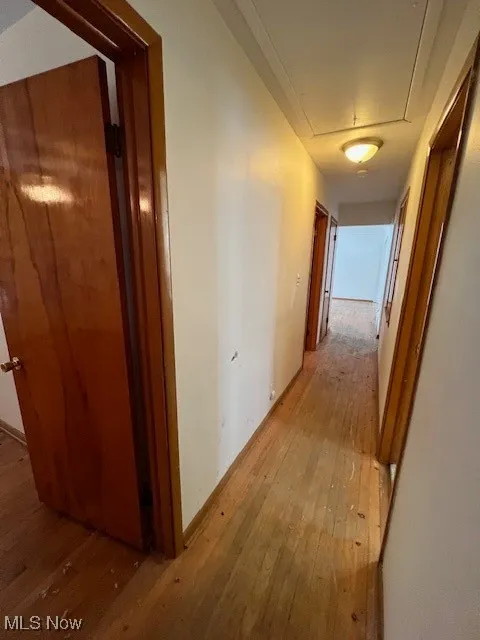 Corridor with light hardwood / wood-style flooring