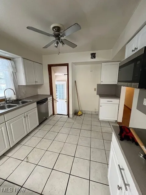 Kitchen featuring sink, white cabinetry, and dishwashing machine