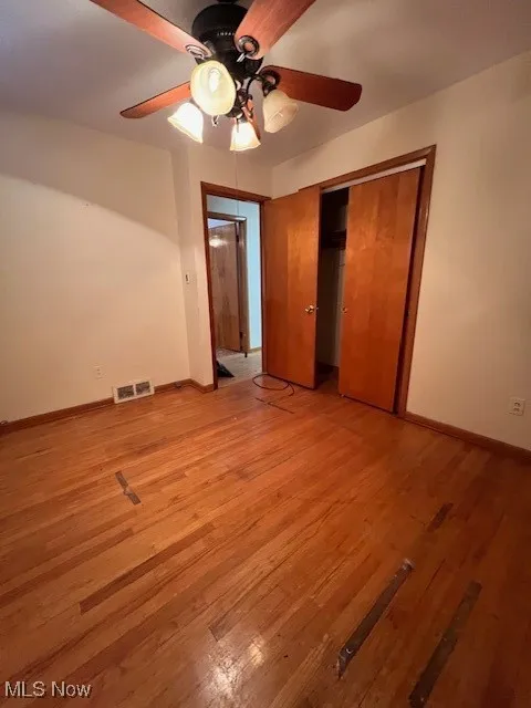 Unfurnished bedroom with a closet, ceiling fan, and light hardwood / wood-style floors