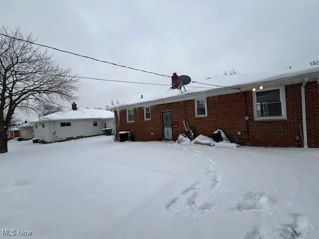 View of snow covered back of property