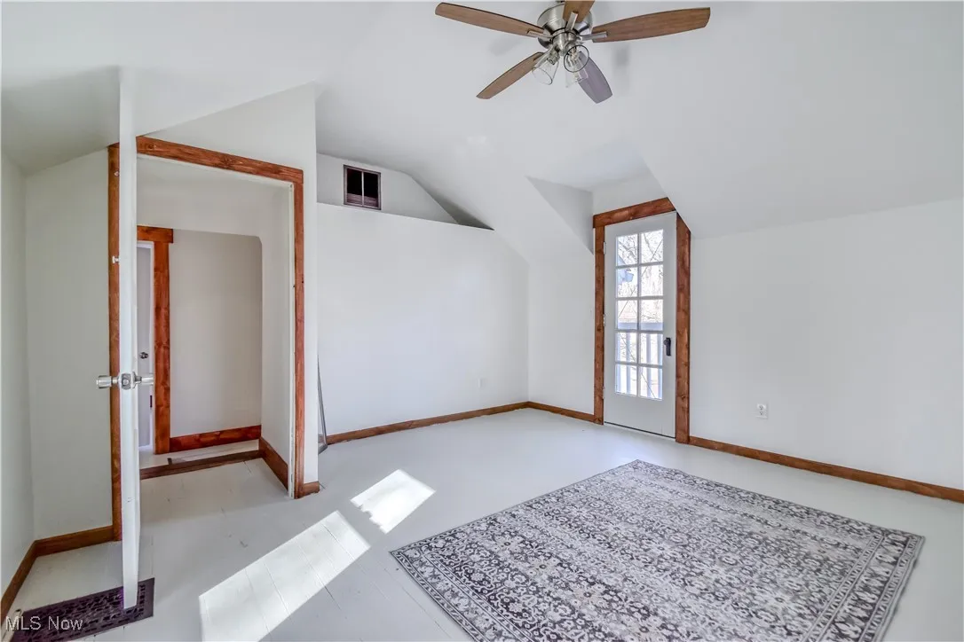 Additional living space with lofted ceiling, baseboards, and ceiling fan