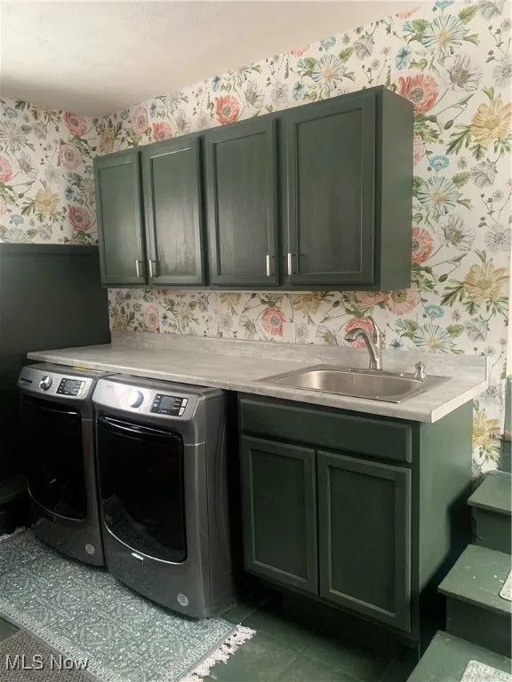 Laundry room with independent washer and dryer, cabinets, dark tile patterned floors, and sink