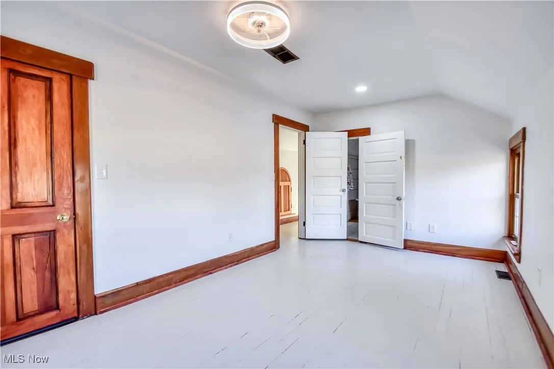 Spare room with visible vents, recessed lighting, lofted ceiling, and baseboards