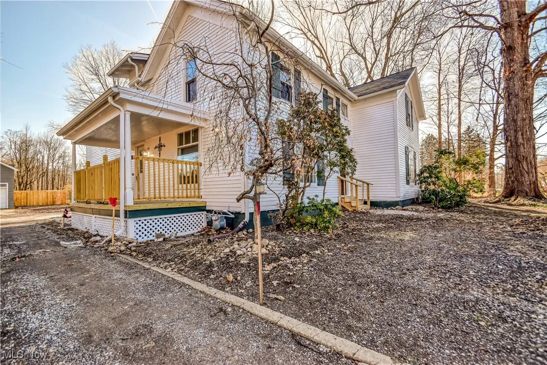 View of home's exterior with a porch and an outbuilding