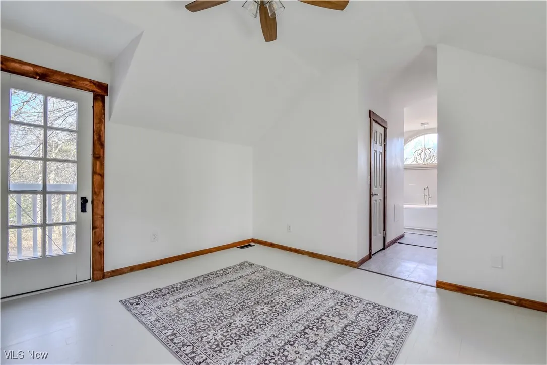 Bonus room with baseboards, lofted ceiling, and ceiling fan