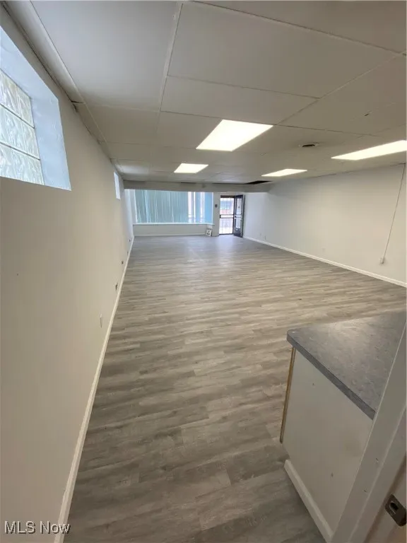 Basement with hardwood / wood-style floors and a drop ceiling
