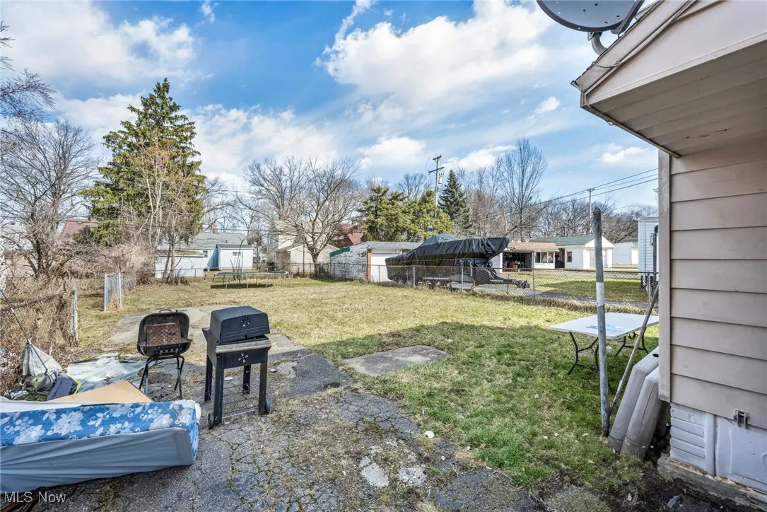 View of yard featuring a patio area, a trampoline, a fenced backyard, and an outdoor fire pit