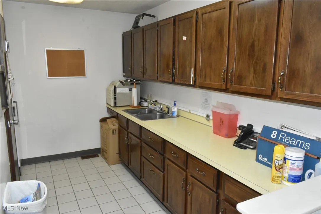 Kitchen with light tile patterned flooring and sink