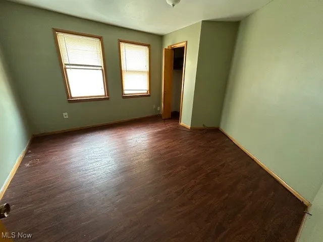 Unfurnished room with dark hardwood / wood-style floors