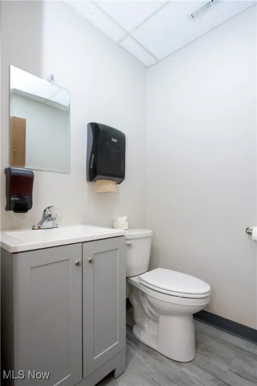 Bathroom with vanity, a paneled ceiling, and light wood-style flooring