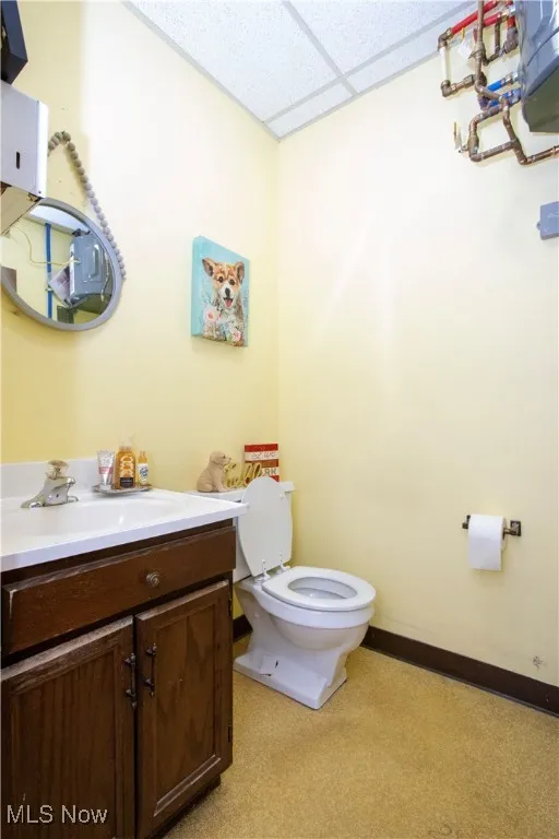 Half bath with a paneled ceiling and vanity