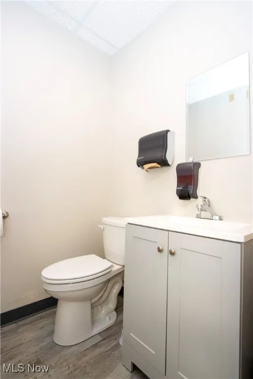 Half bath with vanity and wood finished floors