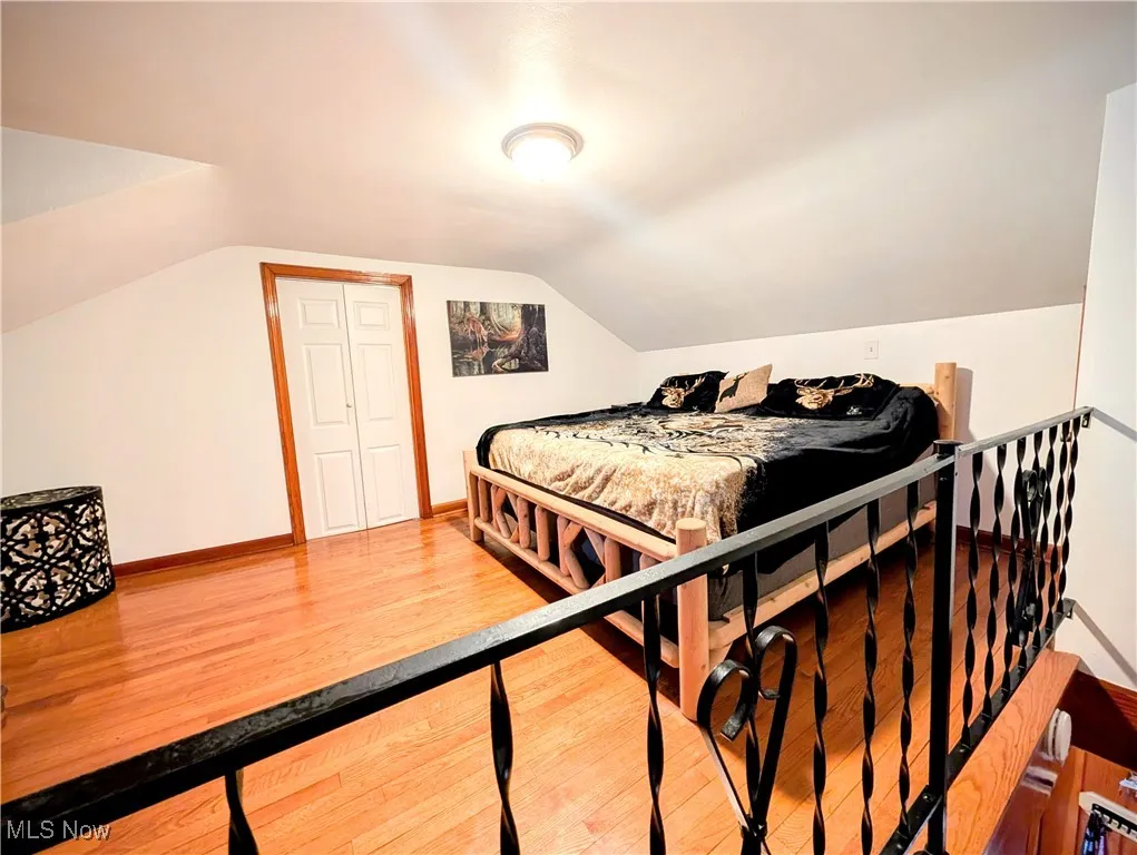 Bedroom featuring hardwood / wood-style flooring and lofted ceiling