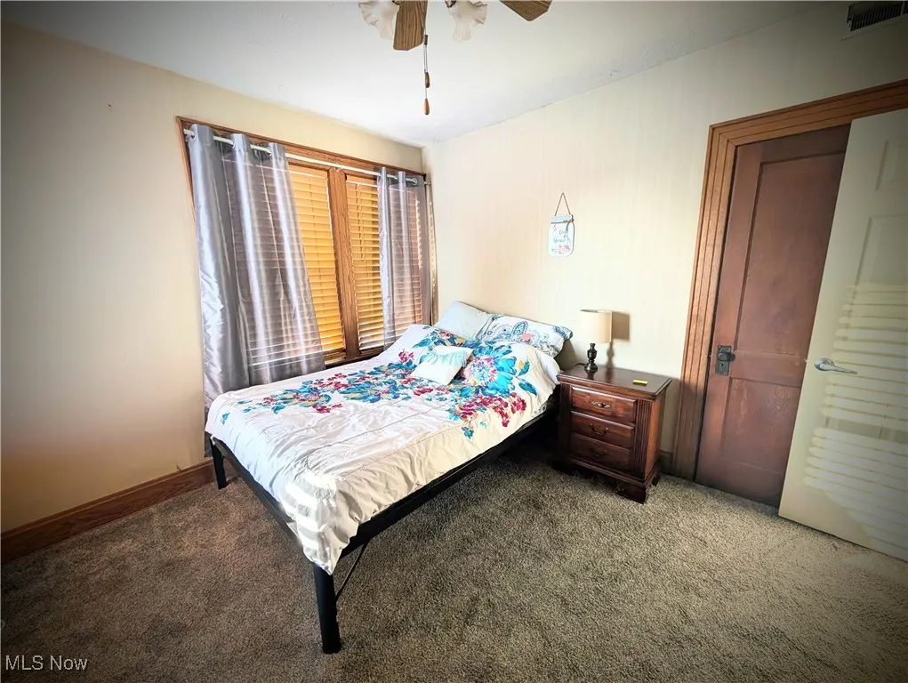 Bedroom with ceiling fan and carpet flooring