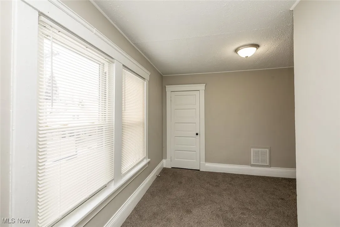 Spare room with dark carpet and a textured ceiling