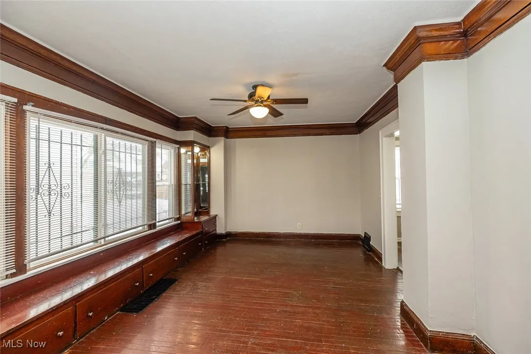 Corridor featuring dark wood-type flooring and crown molding